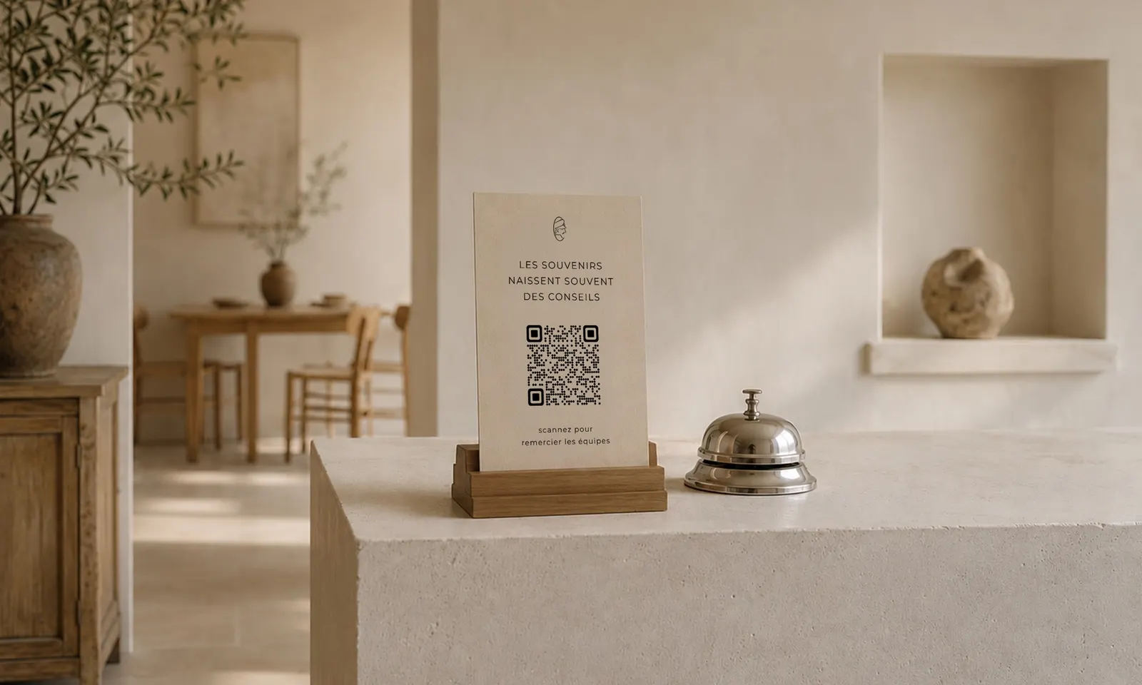 Carte CaptainTips avec QR code posée sur le comptoir d’accueil, à côté d’une clochette de réception
