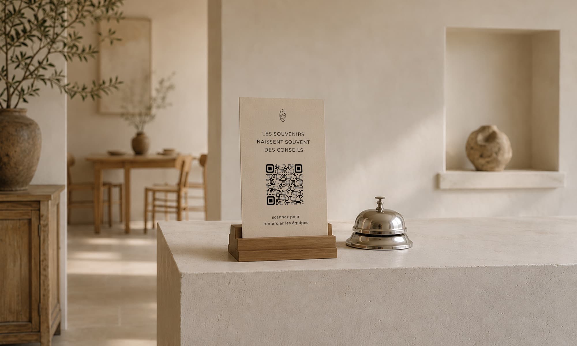 Carte CaptainTips avec QR code posée sur le comptoir d'accueil, à côté d'une clochette de réception