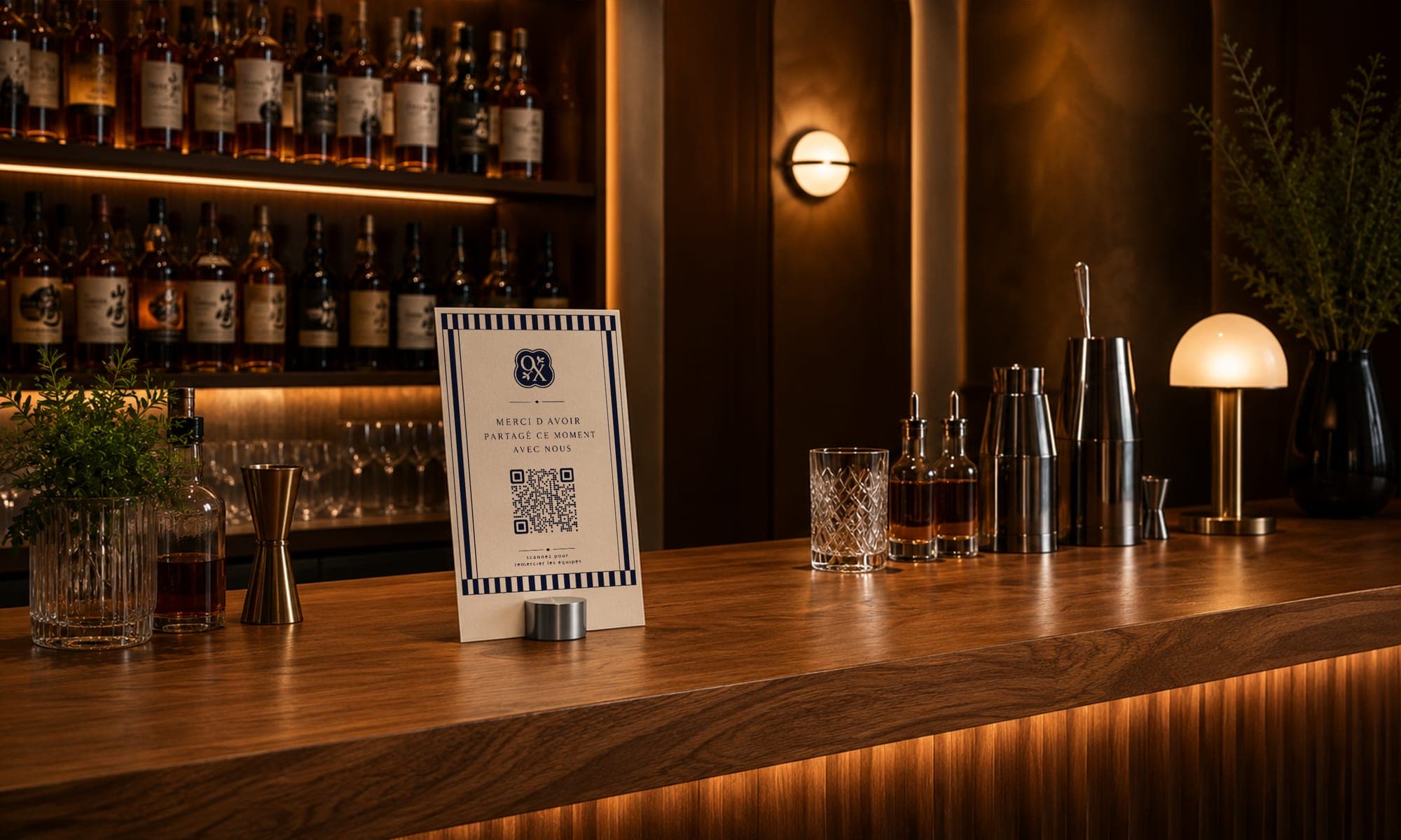 Présentoir CaptainTips avec QR code posé sur le comptoir du bar, bouteilles et verrerie en arrière-plan
