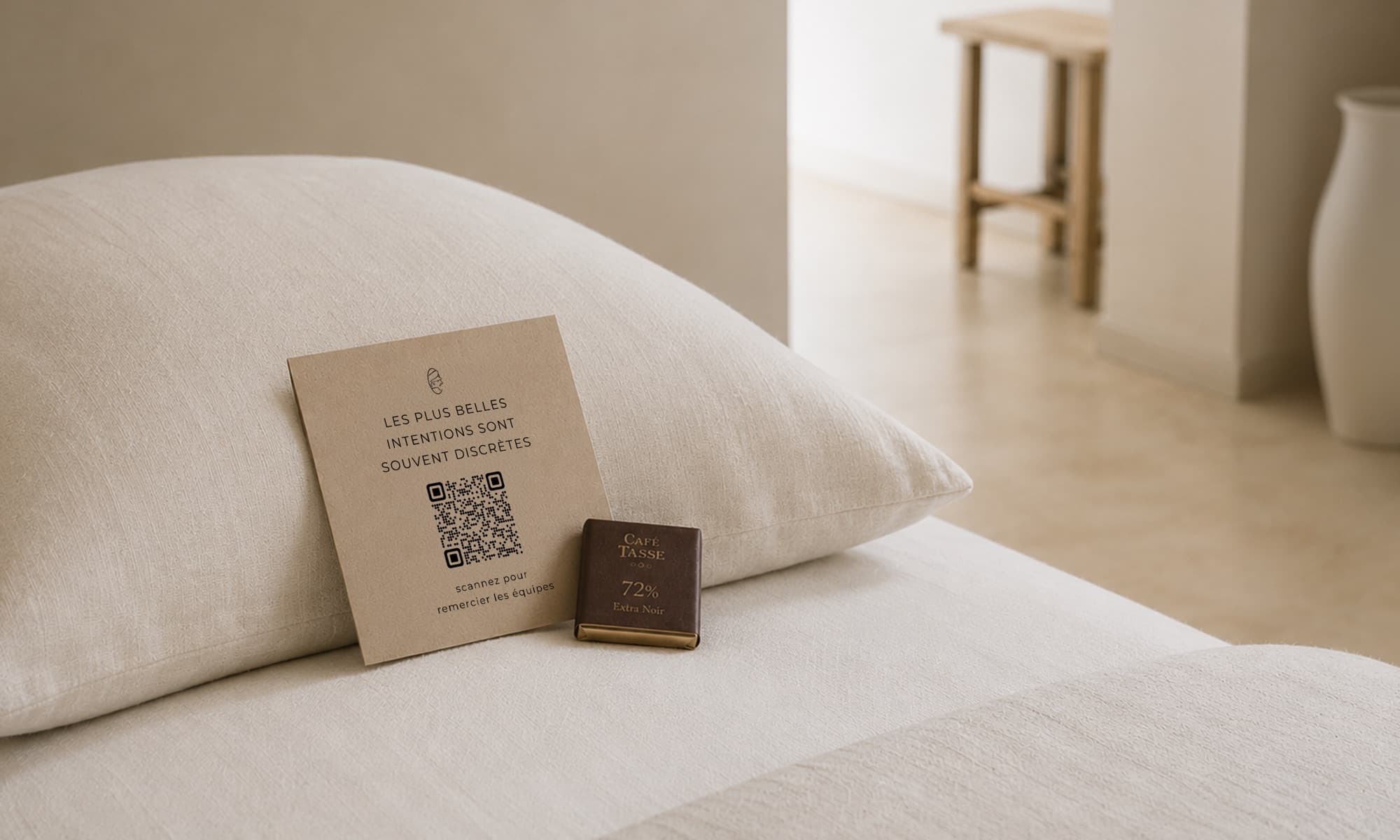 Carte CaptainTips avec QR code posée sur un oreiller, à côté d'un chocolat